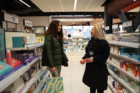 Interior of Boots Battersea Power Station store showing customer speaking to colleague